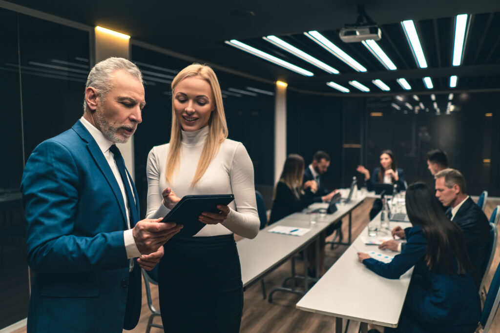 Senior assistant showing leader information on tablet