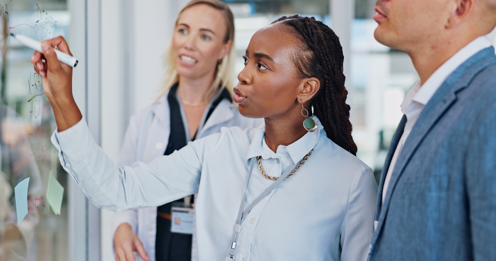Professional leader writing on glass for teamwork solution, brainstorming and timeline for company.