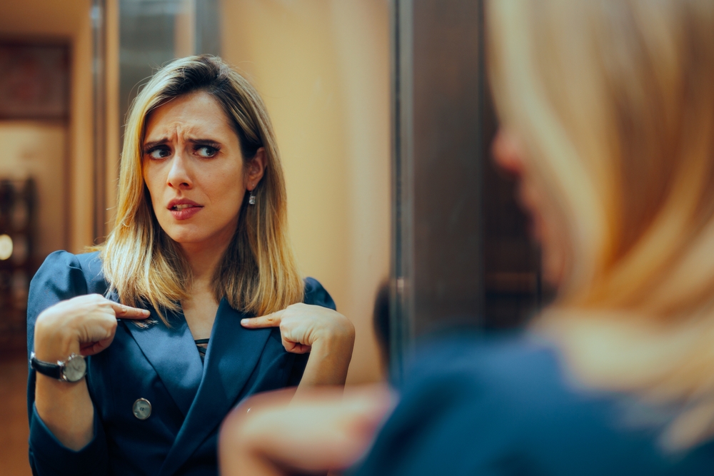 Businesswoman Looking in the Mirror Feeling Insecure.