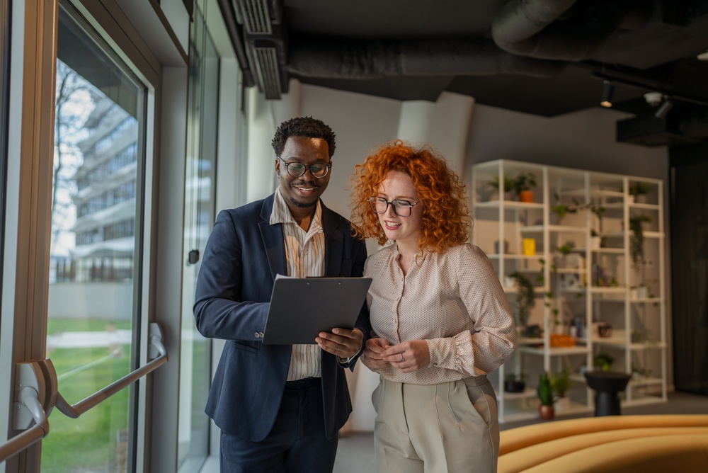 Diverse business colleagues reviewing documents, collaborating on a project and discussing important paperwork during a professional and productive meeting in their modern office environment